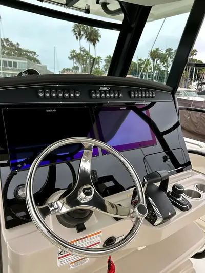 Detailed yacht helm and electronics with palm trees through the windshield