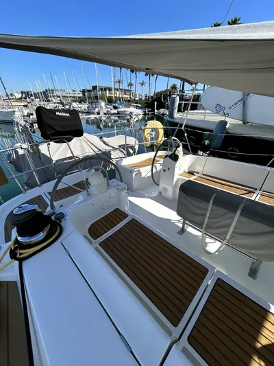 Sailboat cockpit with teak deck and helm, marina in the background