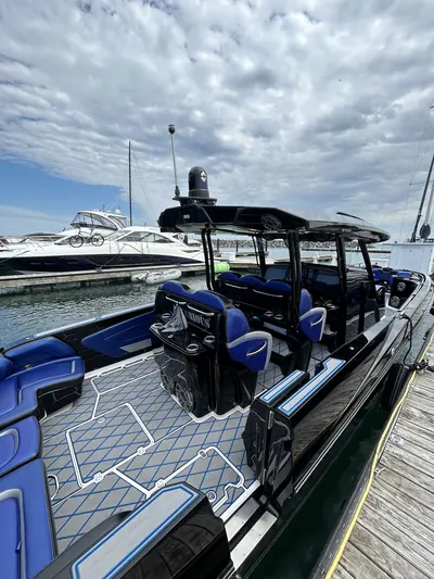 Black center-console boat with blue seating and patterned decking at the marina after detailing